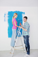 Fototapeta na wymiar happy couple paint wall at new home