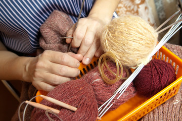 woman's hands with  wool and needles