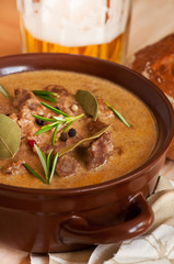 Beef stew in a pot with beer and bread - obrazy, fototapety, plakaty