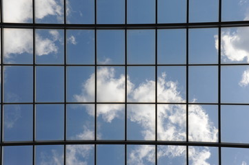 Glasdach mit blauem Himmel und weißen Wolken
