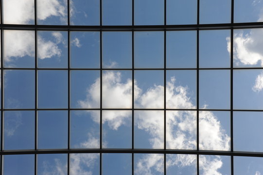 Glasdach mit blauem Himmel und wei&szlig;en Wolken