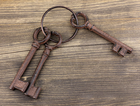 a bunch of antique keys on wooden background