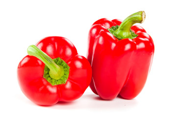 two fresh red peppers on white