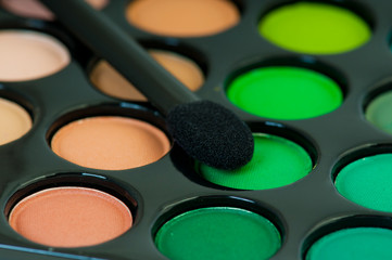 multicolored eye shadows with cosmetics brush