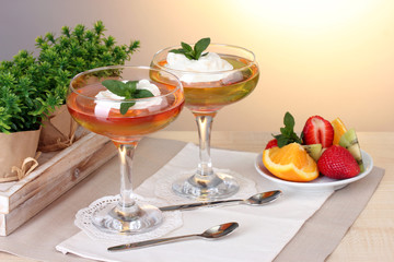 fruit jelly in glasses and fruits on table in cafe