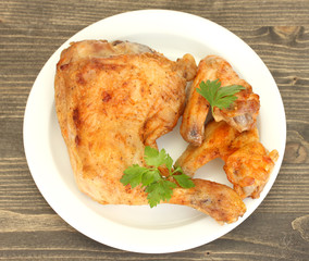 roasted chicken wings and leg with parsley in the plate
