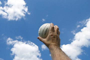 volley ball in man's hand against blue sky