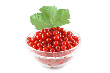 Red currant and green leaves in a glass bowl