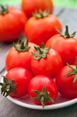 Freshly harvested summer cherry tomatoes on wooden background