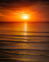 Naklejki  Wschód słońca nad morzem z falą miękką i zachmurzeniem