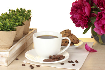 cup of coffee, cookies, chocolate and flowers on table in cafe
