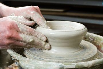 hands of a potter, creating an earthen jar on the circle