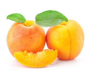 Apricot fruits and slices with green leaves, isolated on white