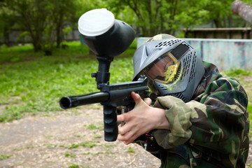 Paintball player in camouflage uniform and protective mask