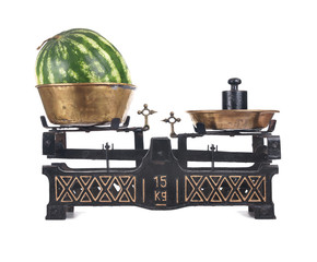 Old-fashioned balance scale with watermelon