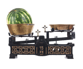 Old-fashioned balance scale with watermelon