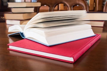 Many different sized colored and shaped books on wood table