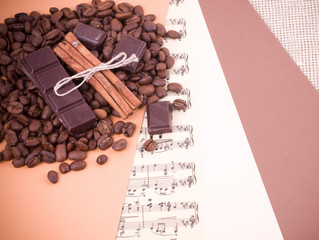 Coffee beans, cinnamon and chocolate on a paper background