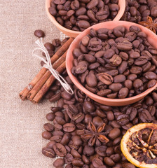 Coffee beans and cinnamon on a sacking background