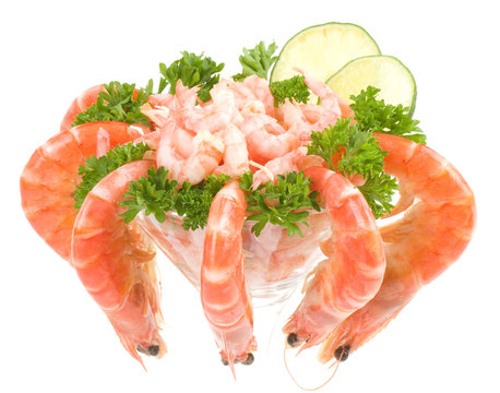 Chilled shrimp served with lime in a martini glass.
