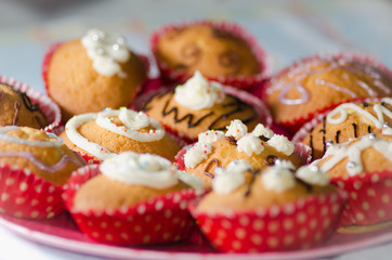 Fototapeta na wymiar Decorated cupcakes with cream, chocolate and sprinkles.