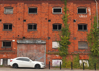 Fototapeta na wymiar Opuszczony budynek z luksusowego samochodu i gołębi
