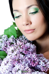 Naklejka premium Beautiful woman with spring flowers of a lilac. Skincare