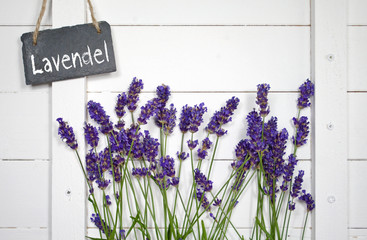 Schiefertafel mit Lavendel vor Holzwand