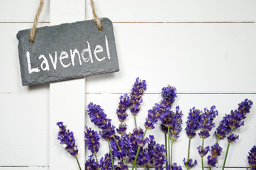Schiefertafel mit Lavendel vor Holzwand