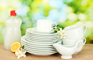 empty clean plates and cups with dishwashing liquid, flowers