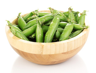 Green peas in wooden bowl isolated on white