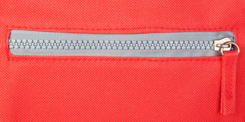 Zipper on a red background. Fastener.