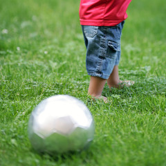 Bub spielt im Park Fußball