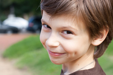 close up portrait of a smiling little boy in the park