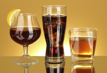 a variety of alcoholic drinks on yellow background