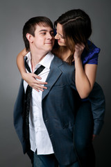 Young couple standing together against a grey wall
