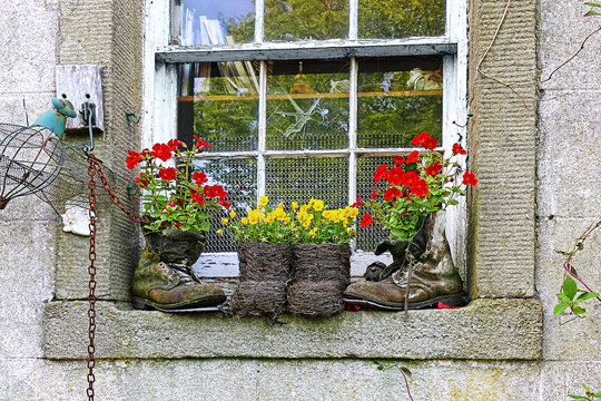 Original flower pots with flowers on the old window