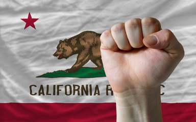 us state flag of california with hard fist in front of it symbol