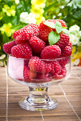 Sweet fresh raspberry fruits in glass goblet