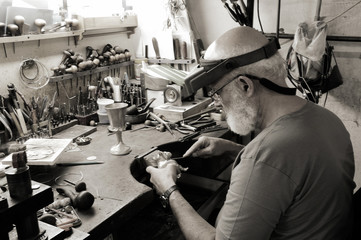 A very old jewelery shop and a jeweler in work