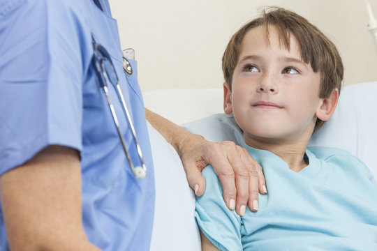 Doctor Or Nurse Comforting Young Boy Child Patient