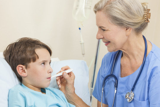 Nurse Or Doctor Taking Temperature Of Young Boy Child Patient