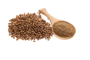 Coriander seeds and powder on a wooden spoon
