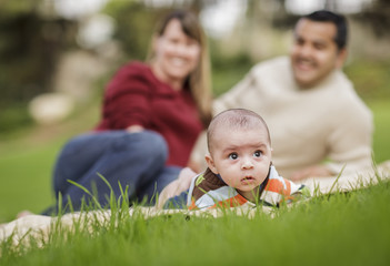 Naklejka na ściany i meble Happy Mixed Race Baby Boy and Parents Playing in Park