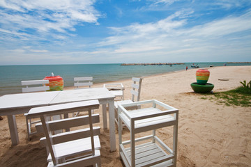 Table and chairs on tropical beach