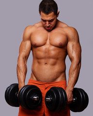 Fototapeta na wymiar Portrait of young man lifting weights