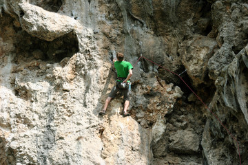 Obraz premium Rock climber climbing up a cliff.