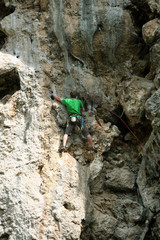 Rock climber climbing up a cliff.