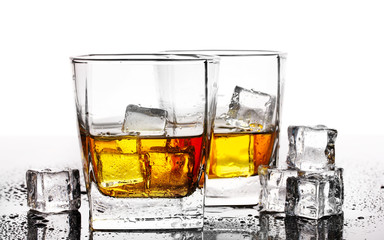 two glasses of scotch whiskey and ice on table isolated on