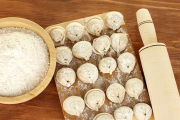 Raw Dumplings on cutting board on wooden background close-up